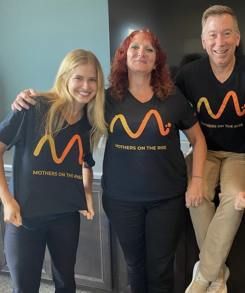 Mothers On The Rise team photo  wearing t-shirts with their logo