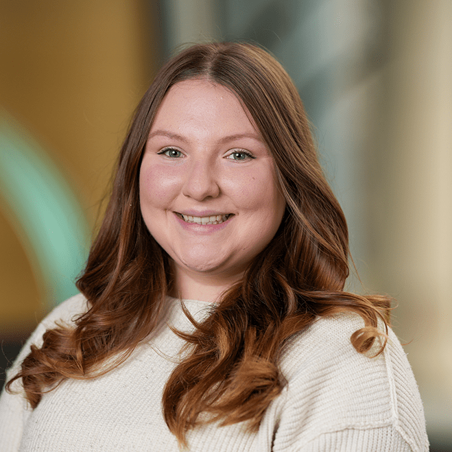 Headshot of a woman in a white sweater