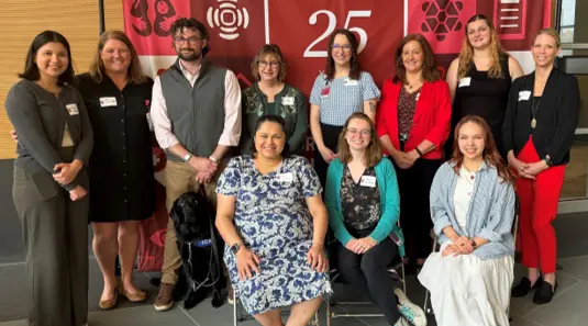 HEART Lab team in front of the CHSR 25th anniversary banner