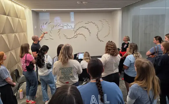 Dance Marathon college students and alumni learning about the EAE Hub Network and how the eye-tracking biomarkers further support the autism diagnostic process