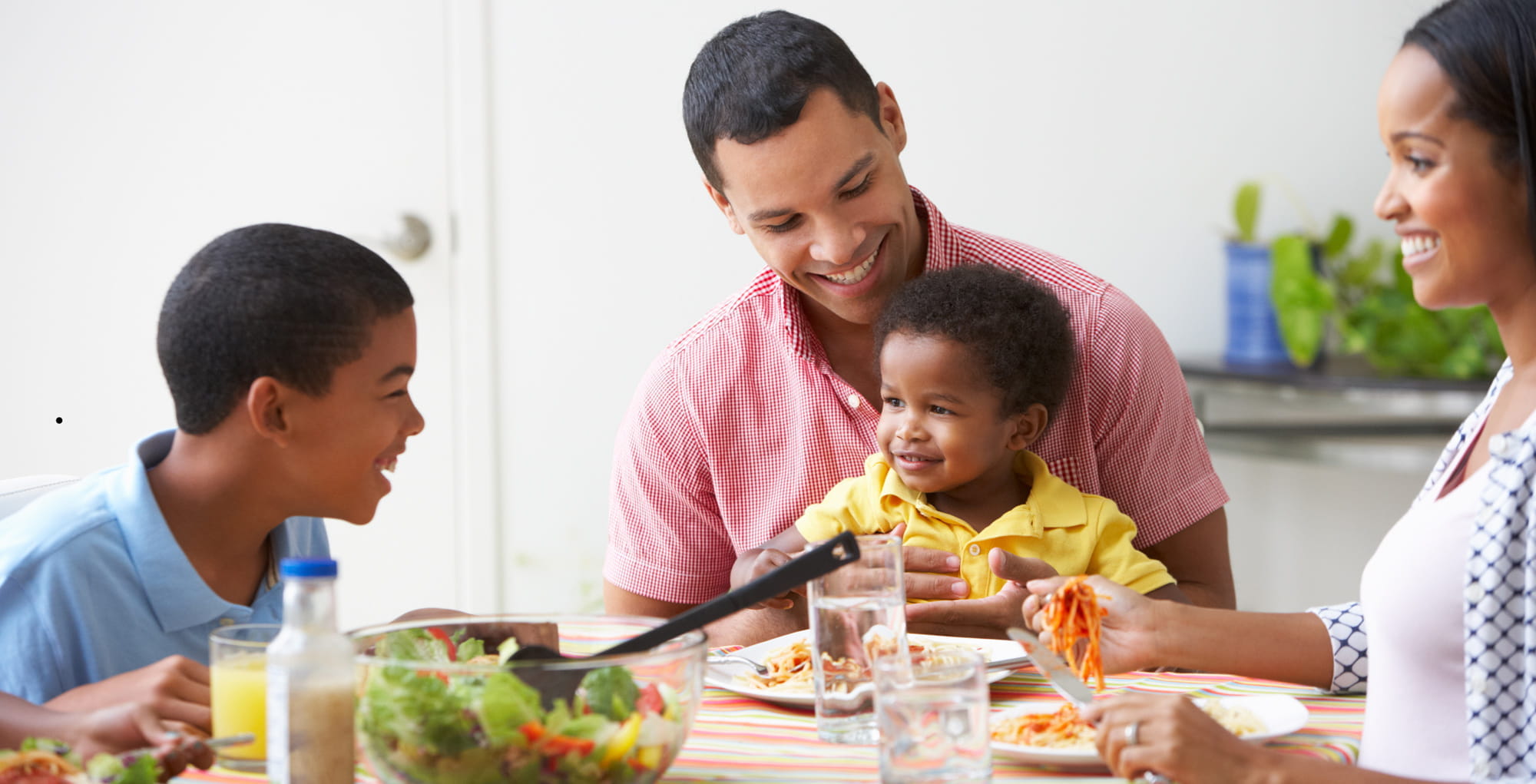 a young black family has dinner together