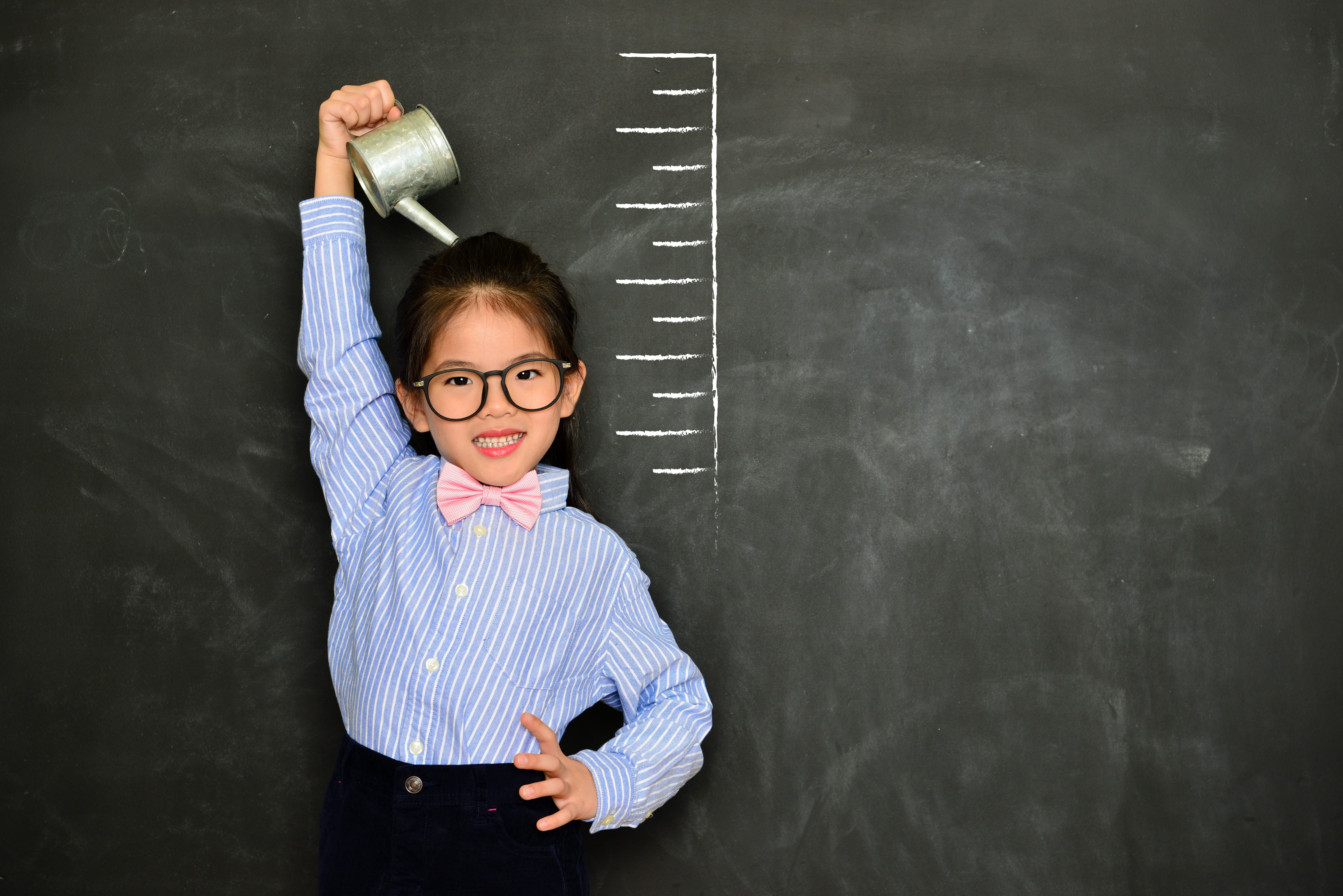A child standing near a growth chart.