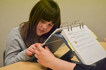 Girl looking at curriculum on a notepad
