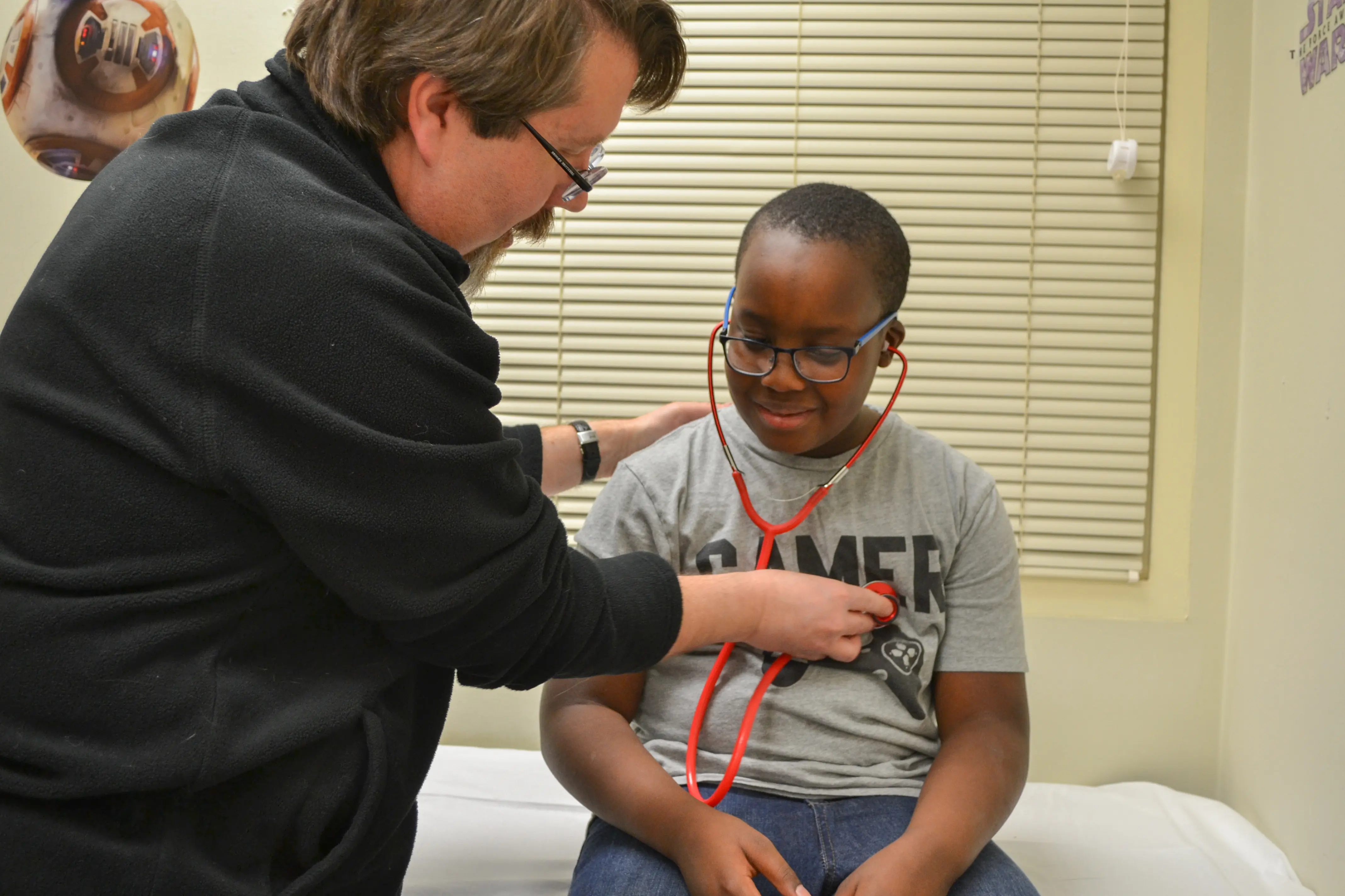 doctor showing young boy his heart beat with a stethoscope
