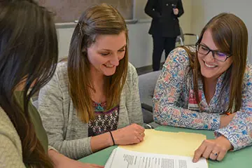 Three female LEND trainees looking at paperwork together