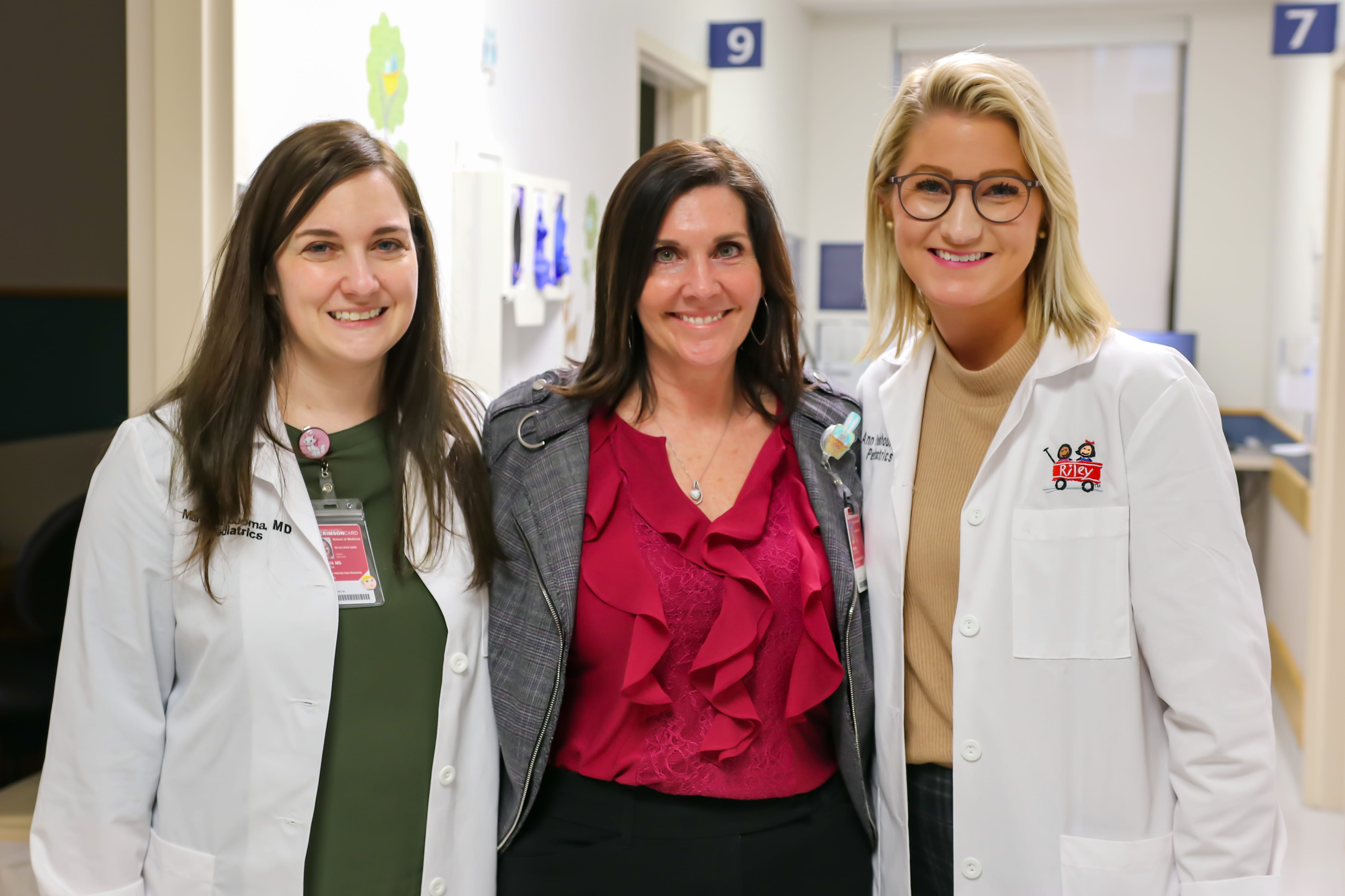 three fellows in white coats smiling together