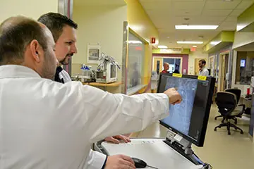Two clinicians looking at an x-ray on a computer screen