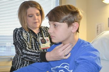 Clinician checking the neck of a young male