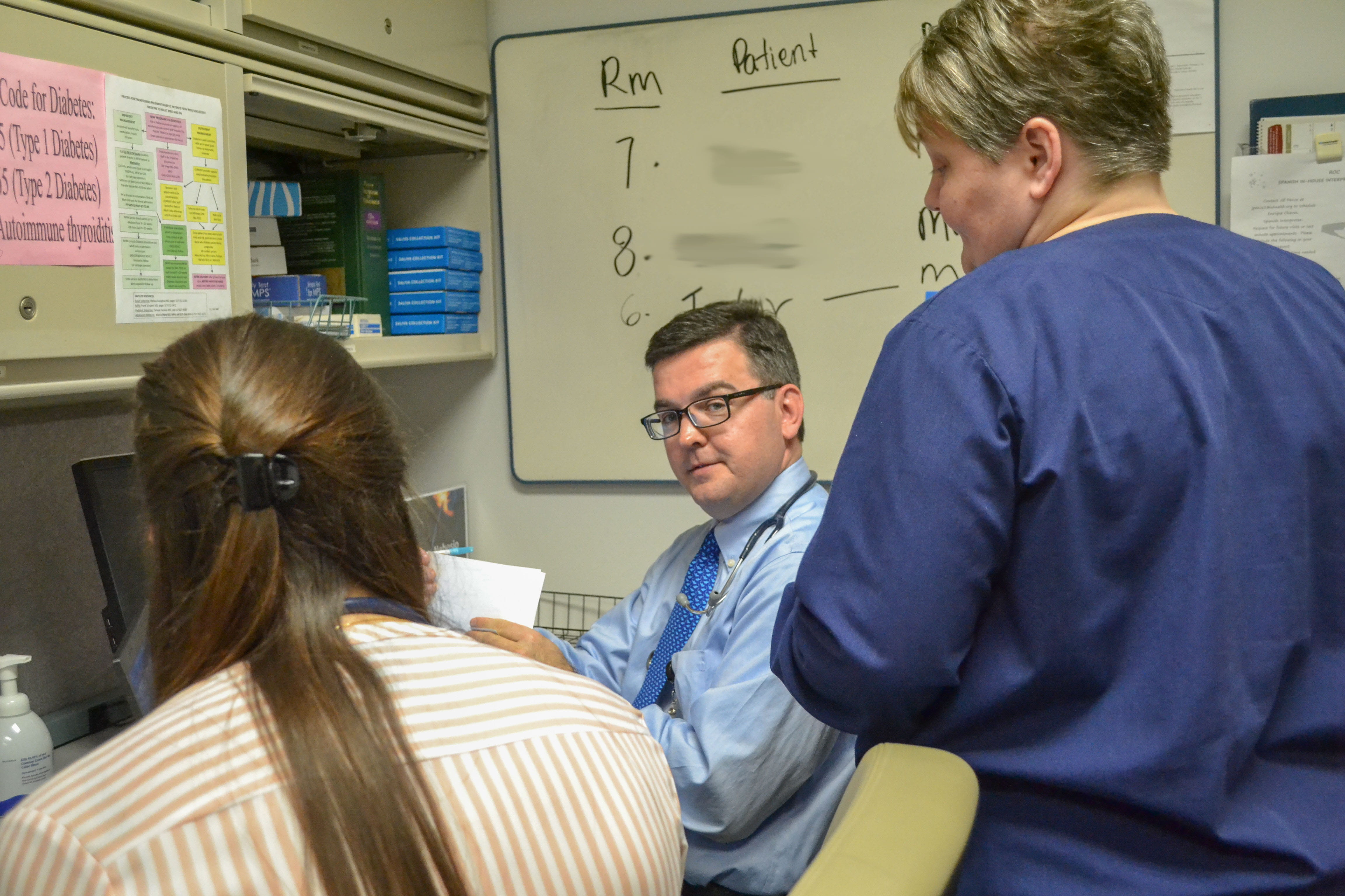 Todd Nebesio, MD, discusses a patient with Zeina Nabhan, MD, and a nurse in clinic