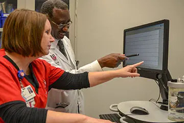Faculty reviews records on computer.