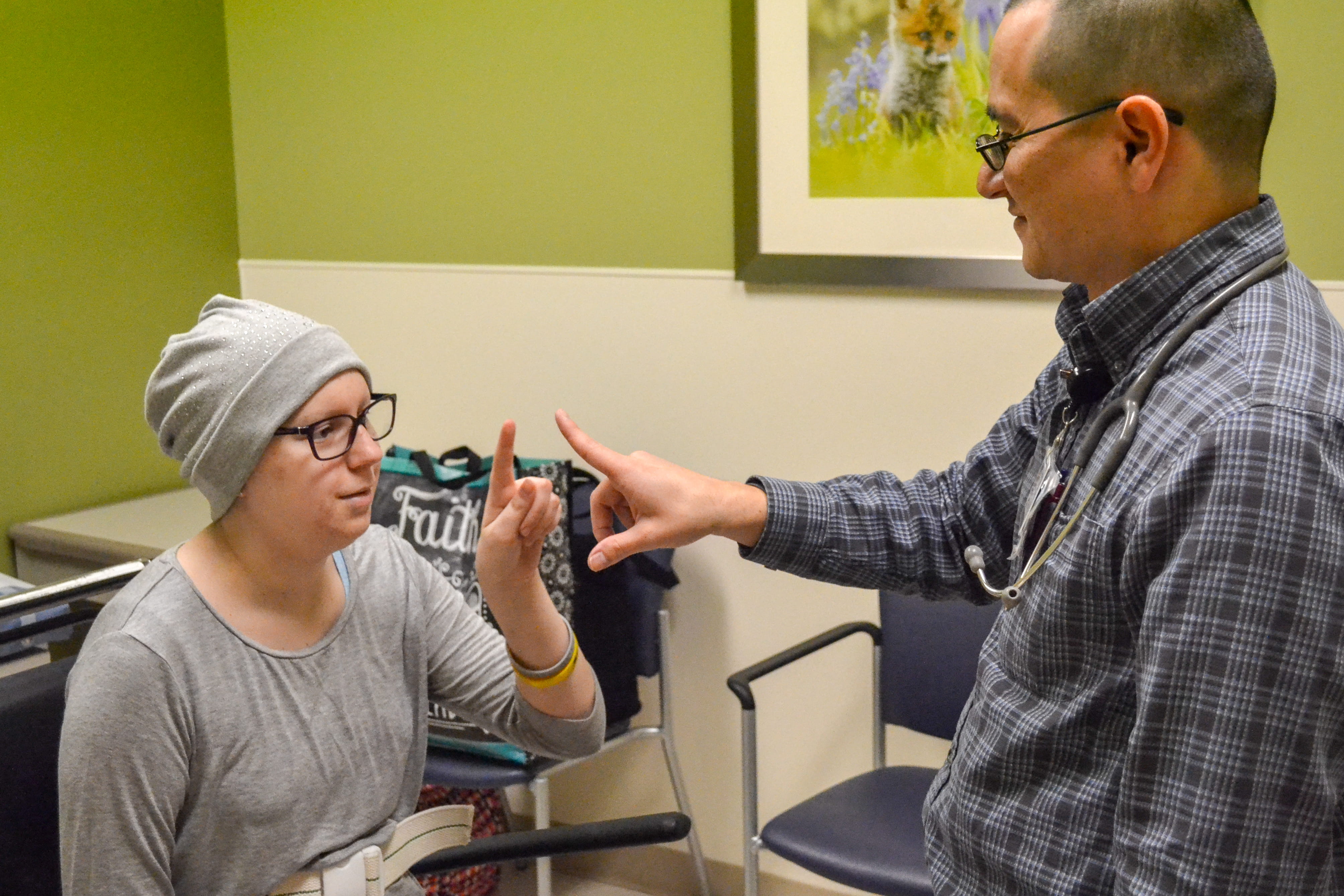 Alex Lion works with a patient in oncology clinic
