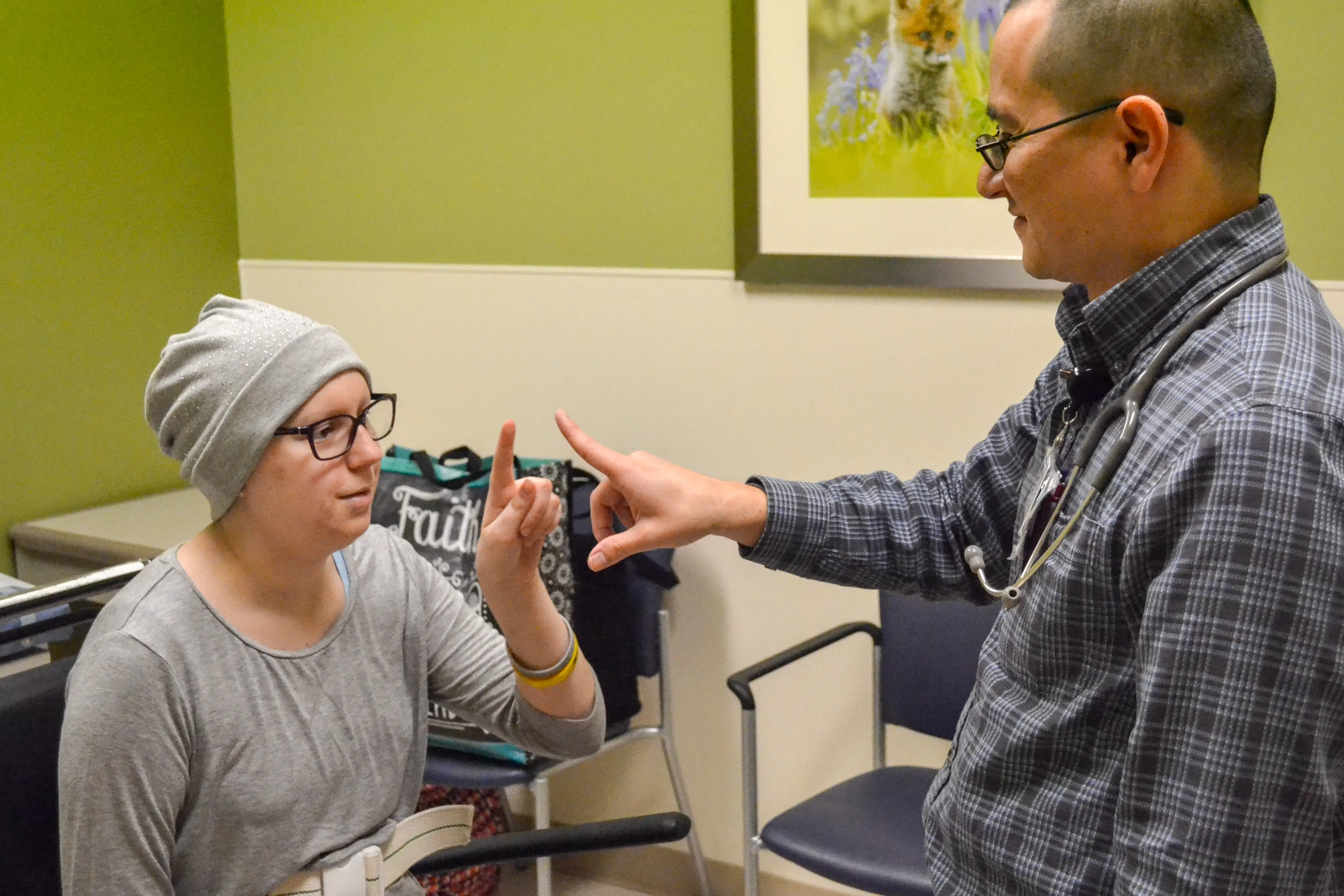 Alex Lion works with a patient in oncology clinic