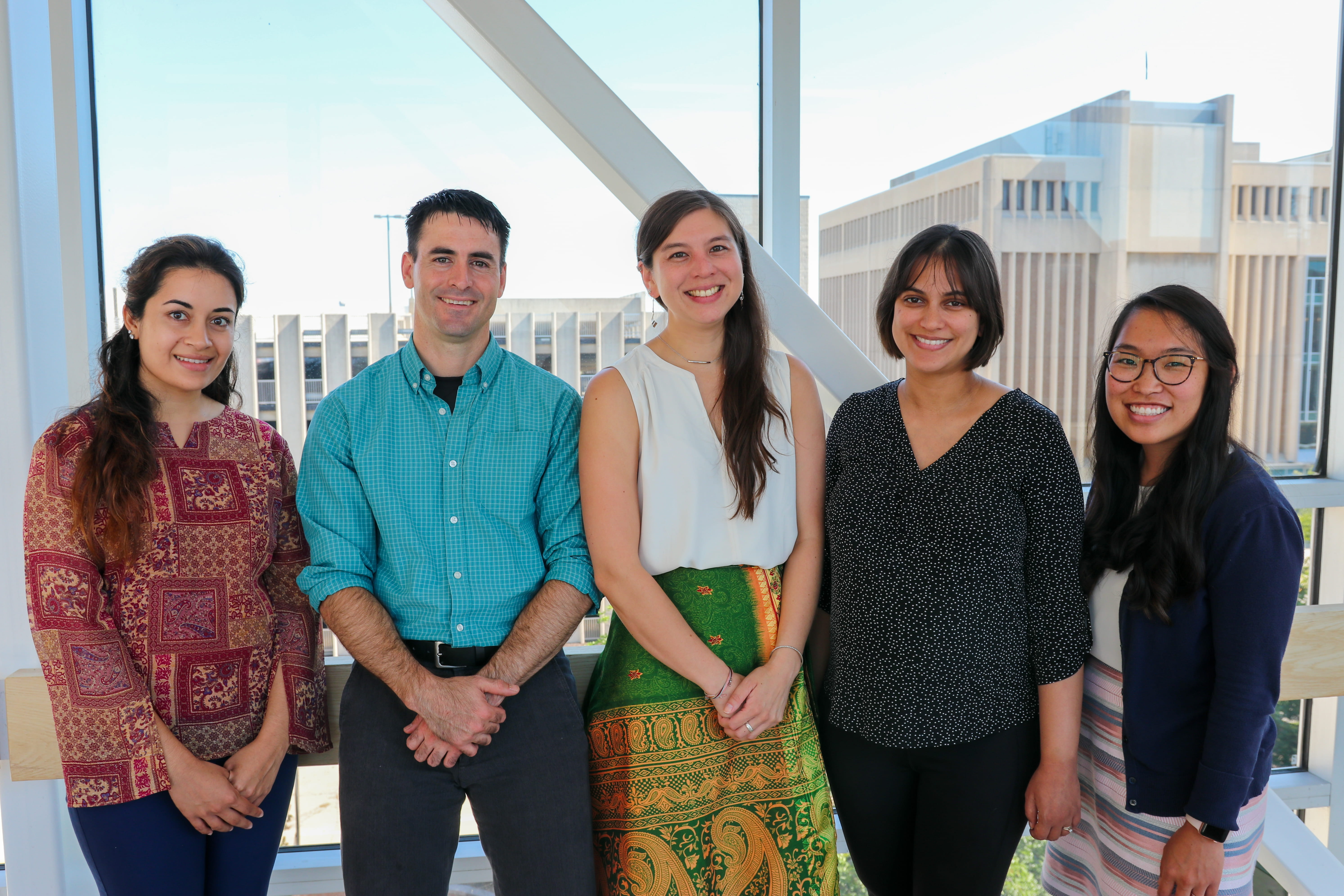 Pediatric Infectious Diseases fellows stand in front of a window overlooking the health center