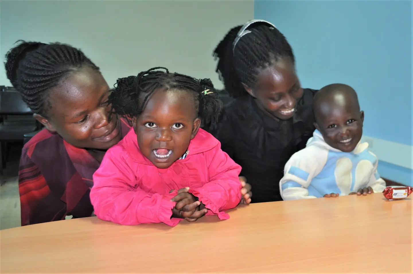 Two women holding young smiling children