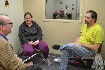 A family sitting in a room for a medical consultation