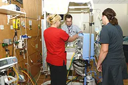 Three providers working in an intensive care unit