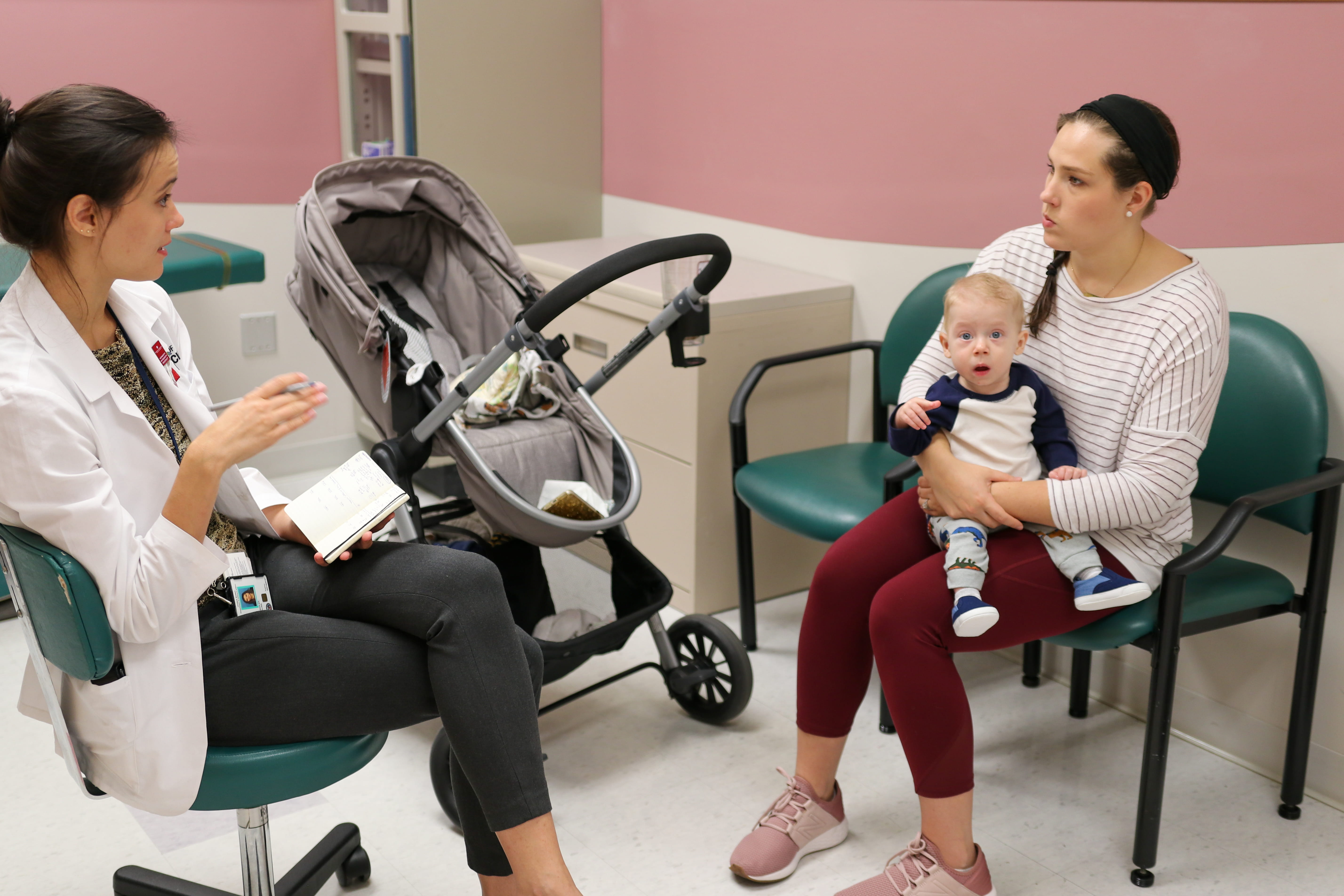 A medical student meets with a family in premie follow-up clinic