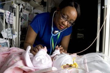 a provider plays with a baby in the hospital