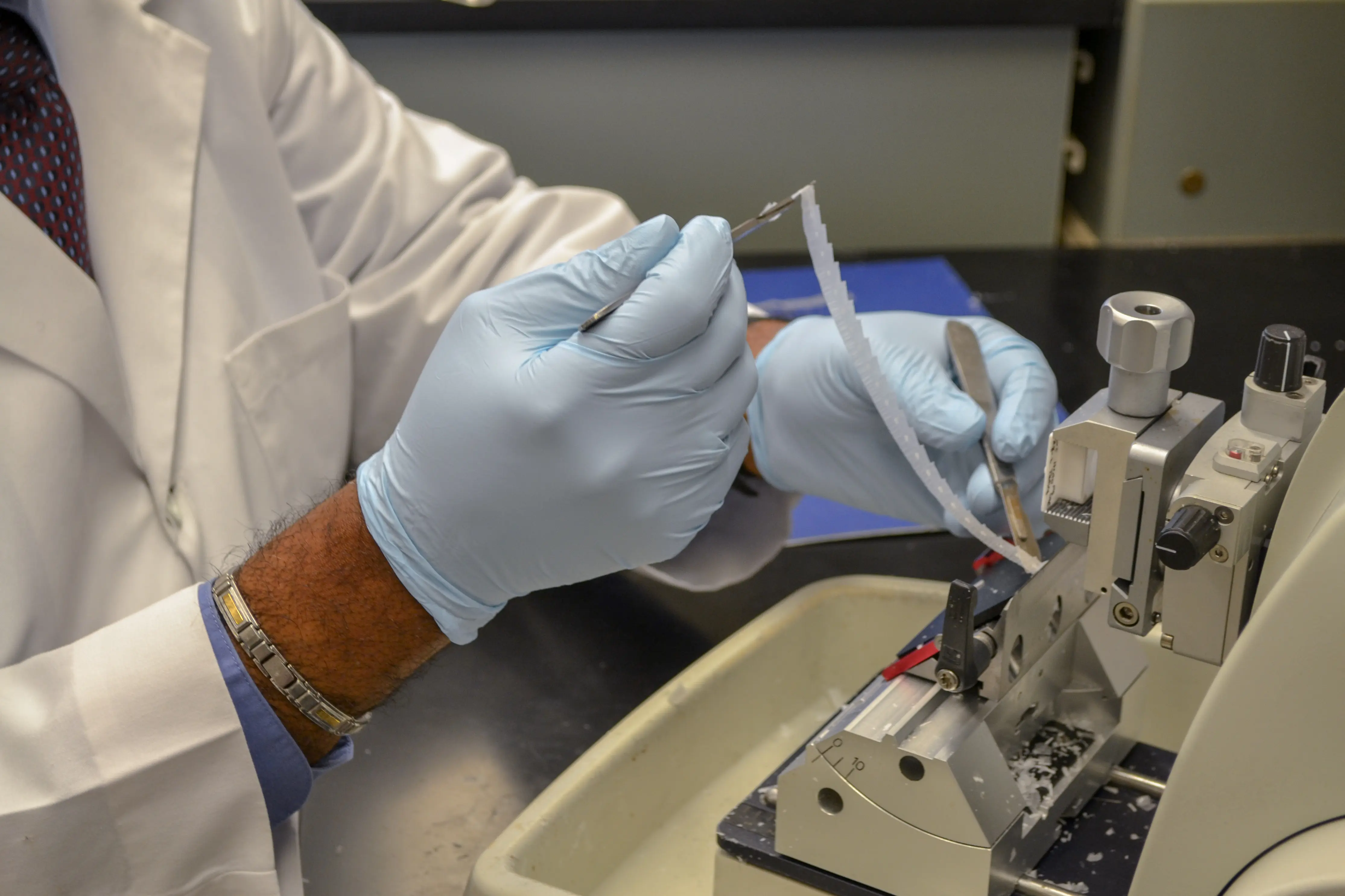 Close up shot of gloved hands running an experiment with a research instrument.