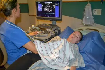 Faculty member runs echocardiography test on patient
