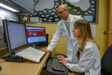 Two providers working on a computer and monitor