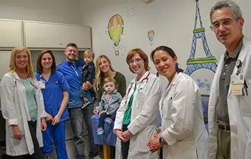 A care team and patient and family in a hospital room