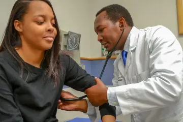 A provider using a stethoscope on a patient 