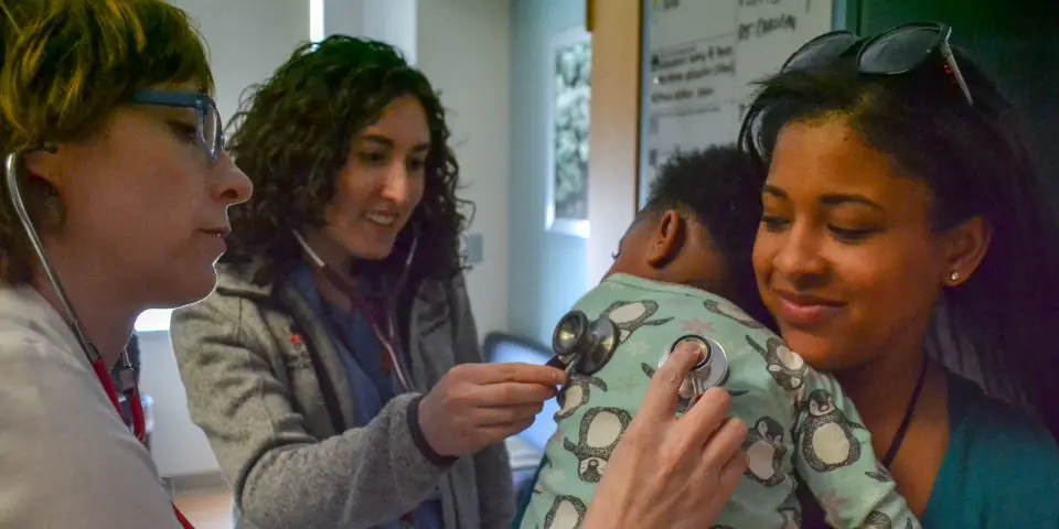 Three providers caring for a pediatric patient