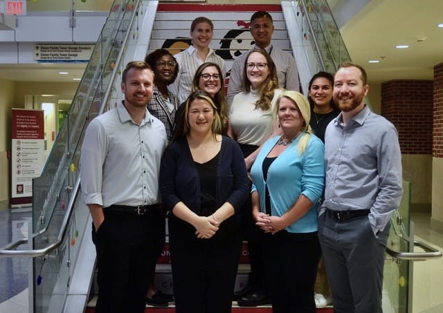 seven fellows stand together and smile
