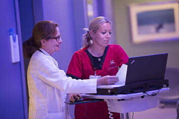Provider and nurse working on a computer