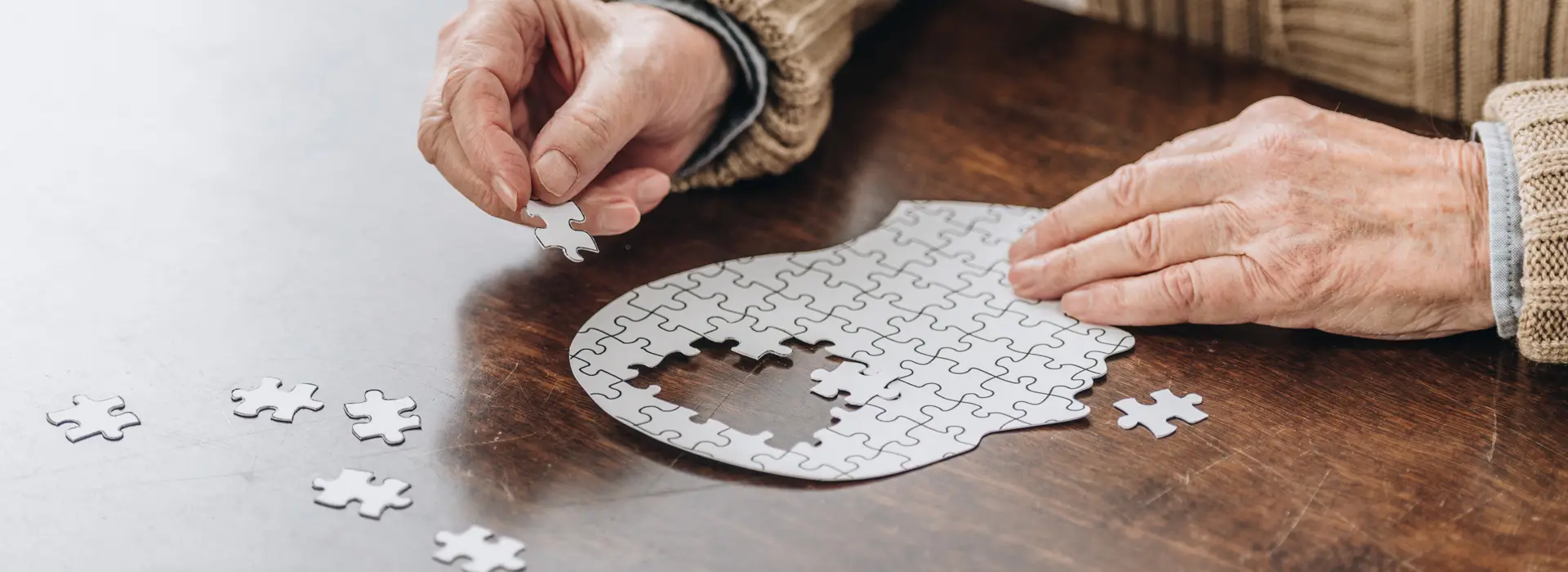 close up of hands putting together a puzzle of a person's head