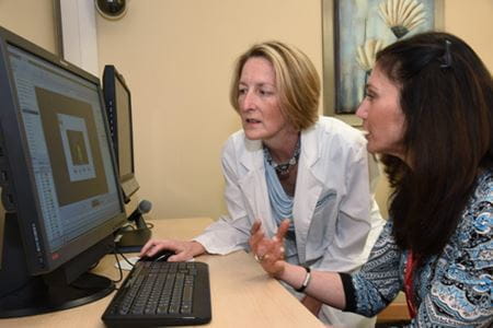 Flora Hammond and Dawn Neumann examine data in their research center