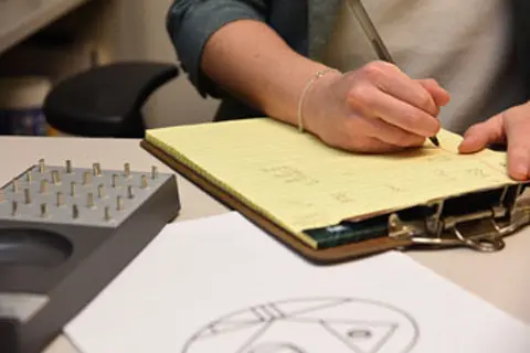 a person writes on a clipboard