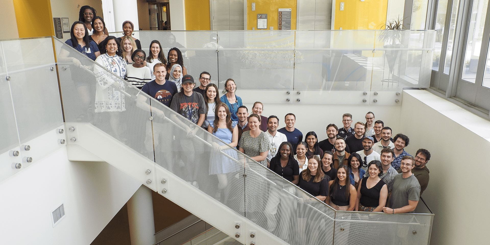 nearly 50 residents stand together on a large open stairway