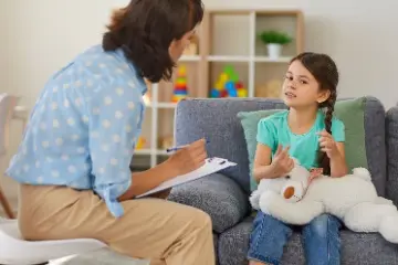 A child psychiatrist meets with a pediatric patient