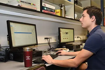 a residents works at a computer in the hospital work station