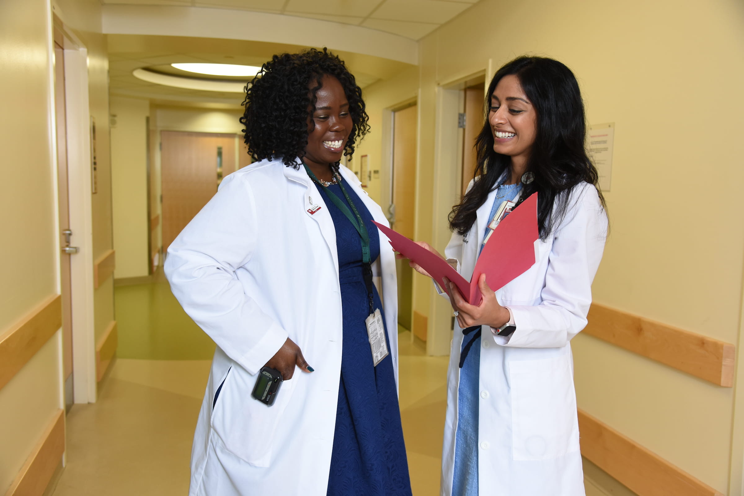 Two female physicians smiling.