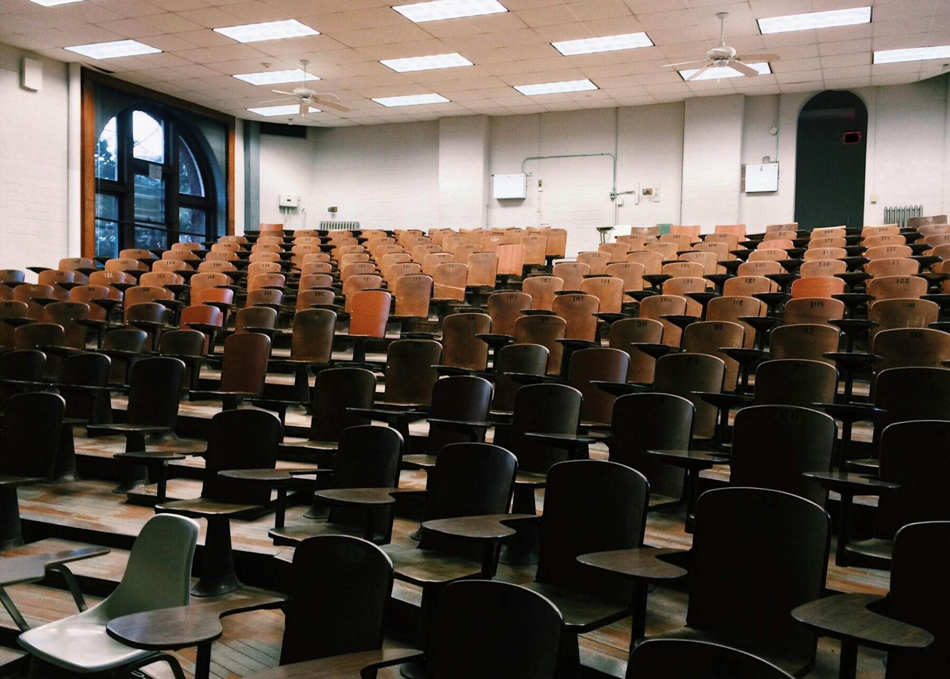 lecture hall with wooden desks.