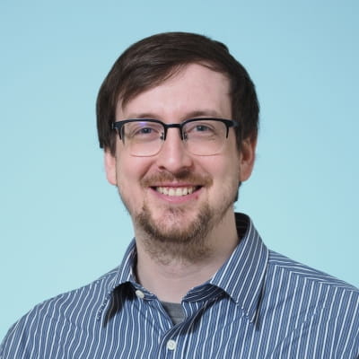 Headshot of Peter Gunderman against a bright blue background.