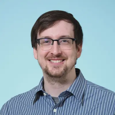 Headshot of Peter Gunderman against a bright blue background.