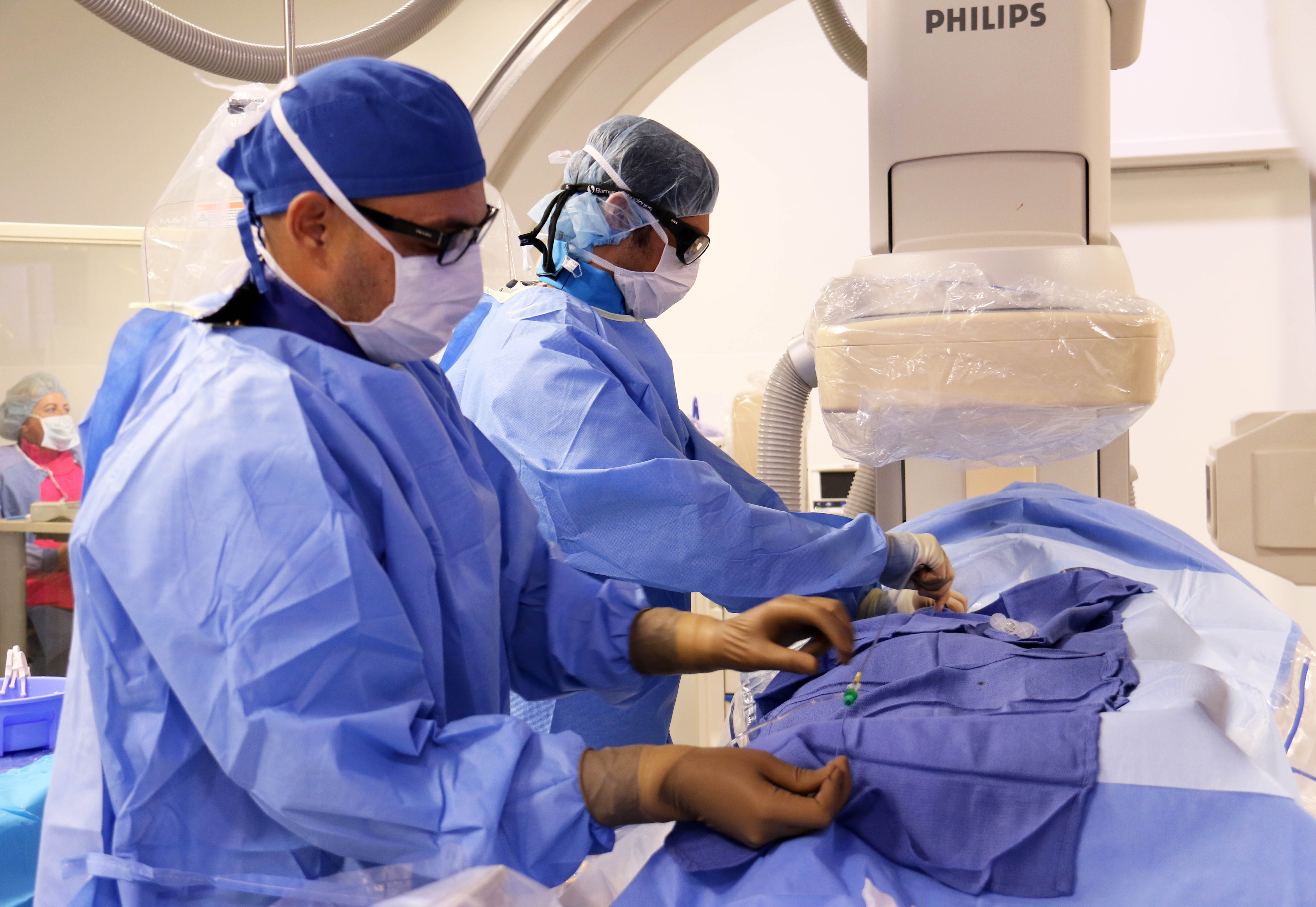 Two physicians perform an interventional procedure.