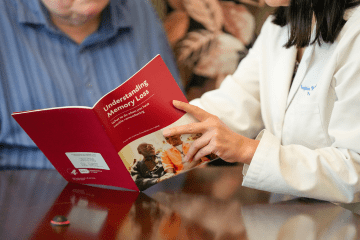 a provider shows a patient some details in a booklet titled "understanding memory loss"