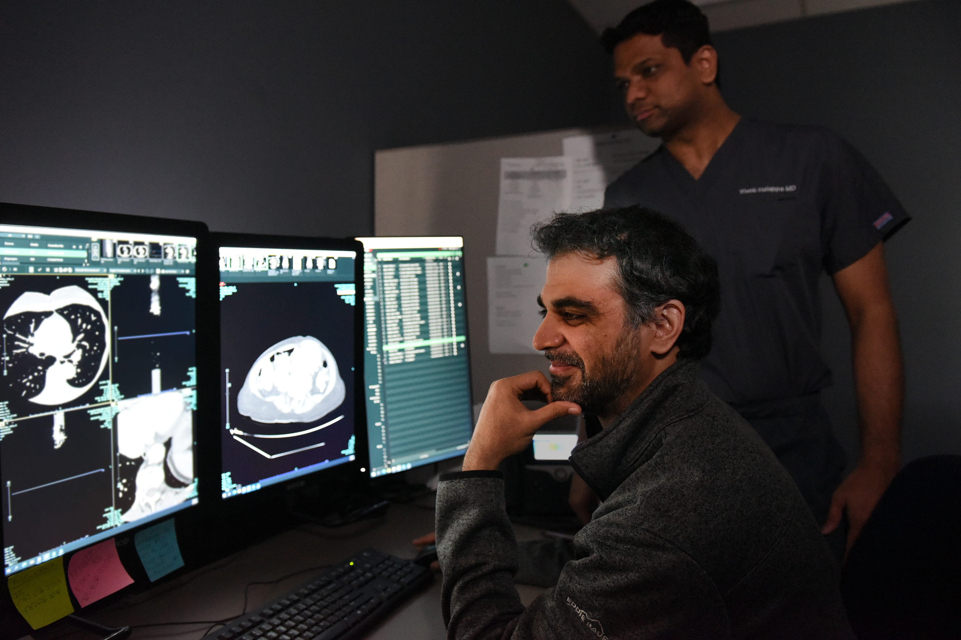Two male radiologists view an abdominal scan.