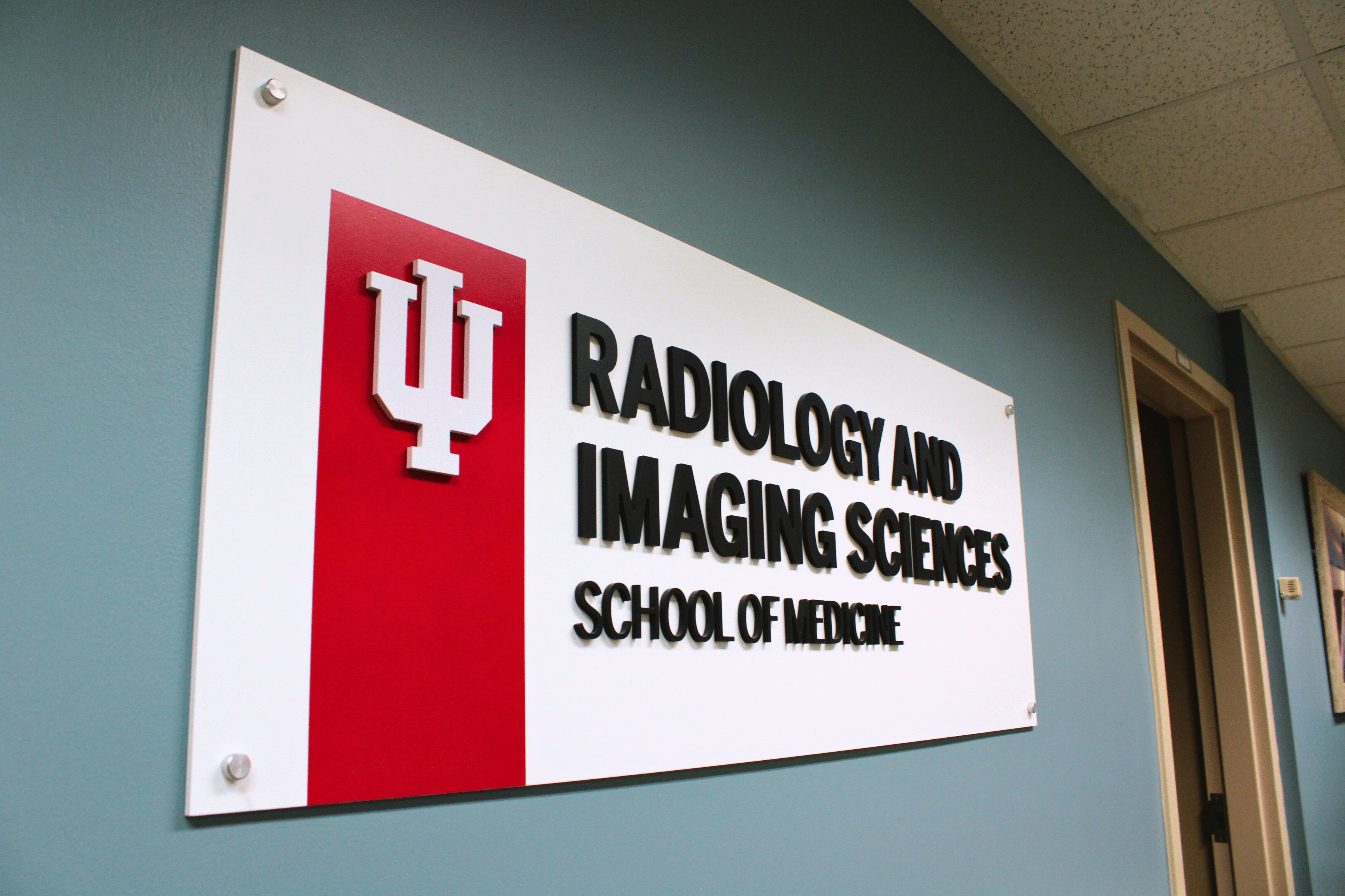 Sign on a hallway wall that reads "Radiology and Imaging Sciences" with the IU trident
