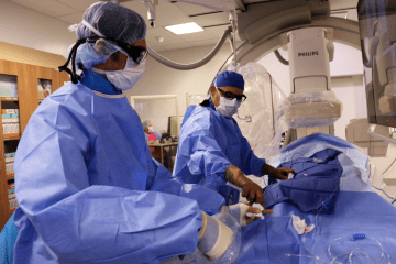 Two physicians perform an interventional procedure.