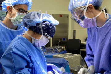Trio (one male, two female surgeons) of Acute Care Surgeons in OR