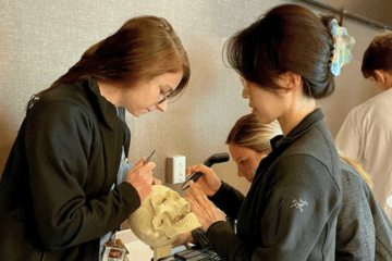 Two vascular surgery residents practice surgery during a training lab
