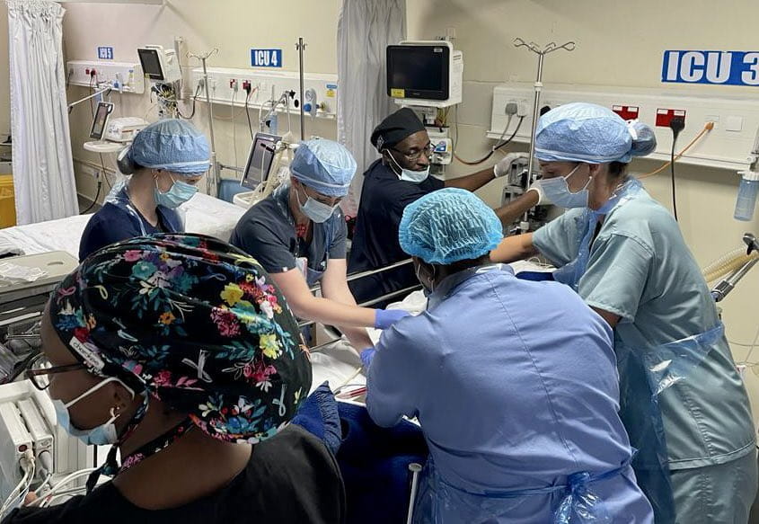 diverse group of 6 medical professionals at MOI Teaching Hospital providing medical care to a patient