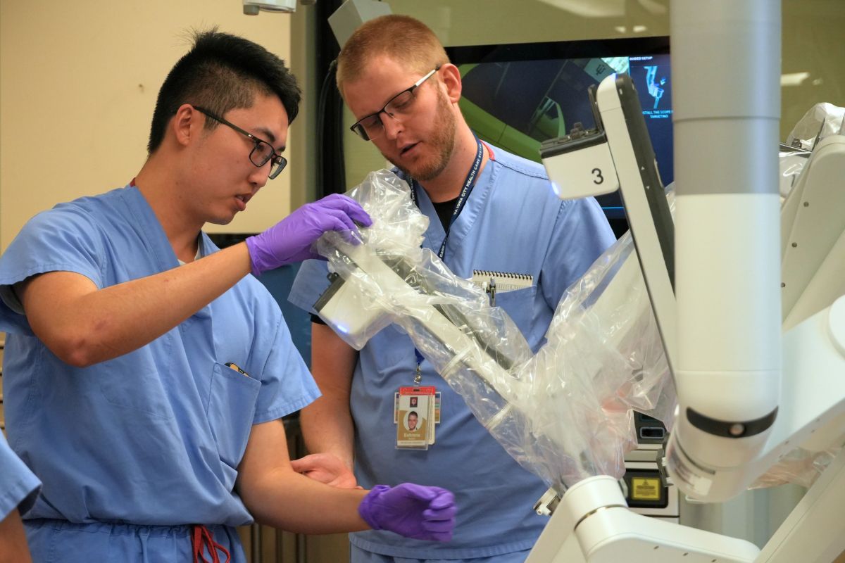 A medical student and fellow Nathan Behren, MD examine a robotic surgical device