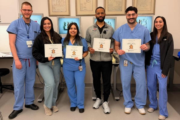 IU RISE fellows celebrate with four fourth year IU medical students, holding up certificates, in the MISAS course.
